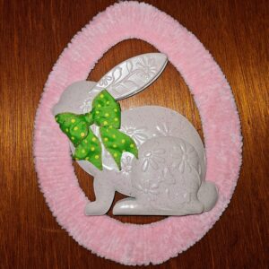 Handmade pink oval Easter wreath featuring a beige embossed bunny with green polka dot bow.