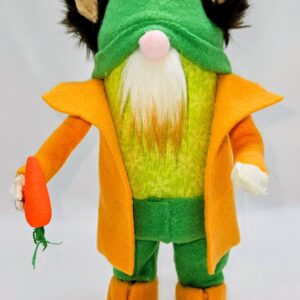 Handmade bunny gnome named Carrot wearing a green hat with tall bunny ears, orange coat, green outfit, and holding a bright orange carrot.