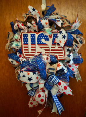 Patriotic USA wreath with red, white, and blue ribbons and large USA sign in center