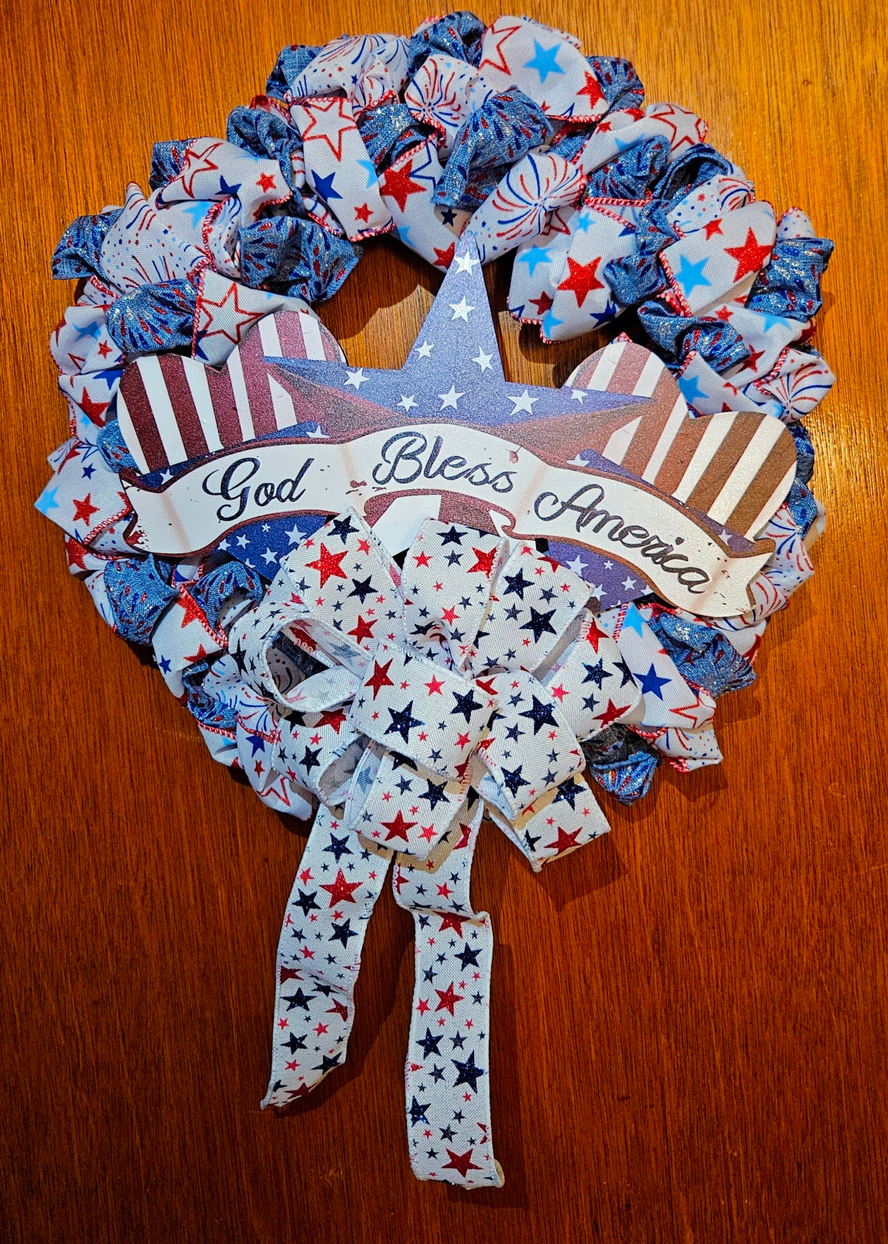 God Bless America wreath with star and hearts centerpiece and red white blue ribbon pouf design