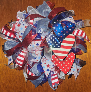 patriotic wreath with wooden hearts featuring American flag designs in red white and blue
