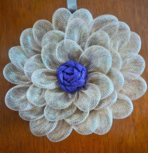 Handmade rose gold daisy wreath with metallic pink-gold petals on a door