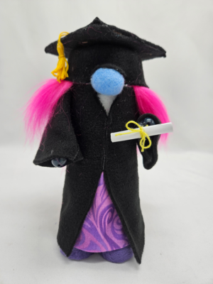 Handmade graduation gnome girl with pink hair, black robe, purple dress and diploma scroll