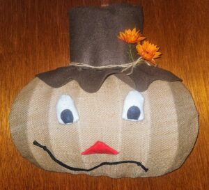 Cornelius Cornie handmade scarecrow head door hanging with burlap face, black top hat and orange flowers